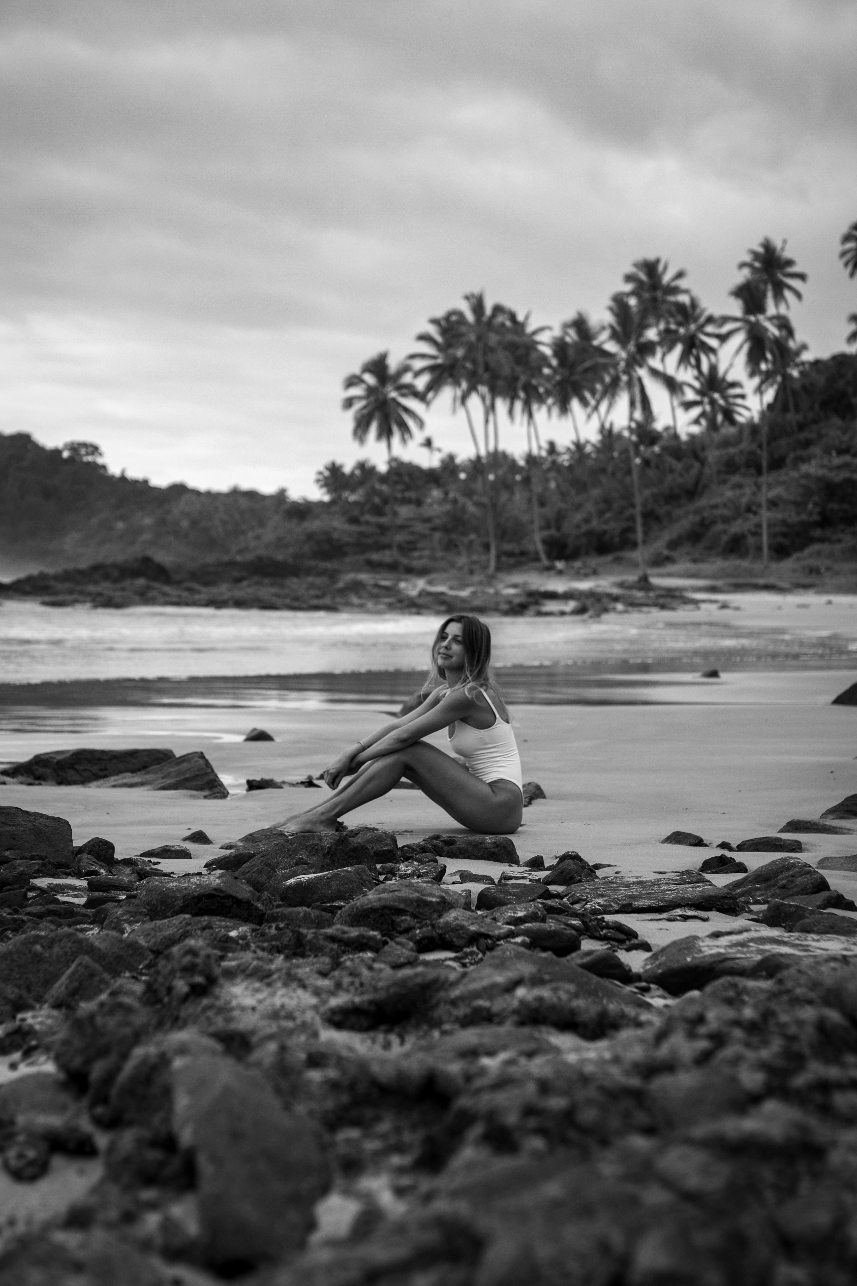 A woman seated on the beach in Itacaré, photographed in black and white